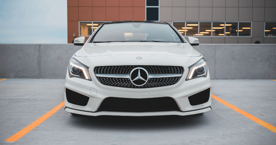 Front view of a white Mercedes-Benz CLA-Class parked in a rooftop lot