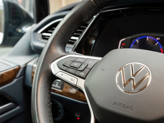 Close-up of a Volkswagen steering wheel with control buttons and dashboard display