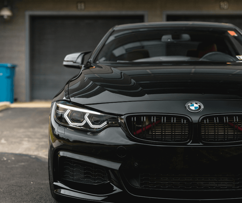 Close-up of black BMW M-series front end featuring LED headlights and blacked-out kidney grilles