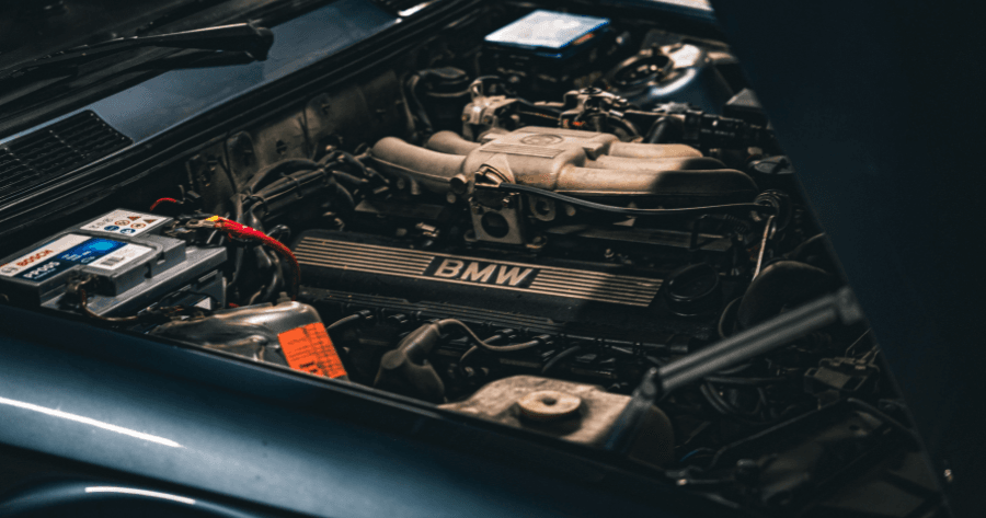 Vintage BMW inline six engine bay with classic valve cover badge