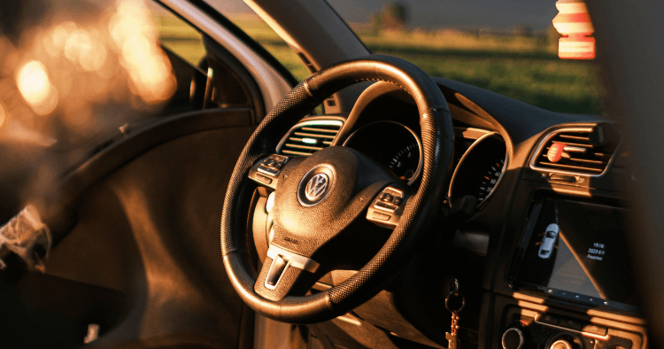 Close-up of a Volkswagen steering wheel and dash lit by warm evening sunlight.
