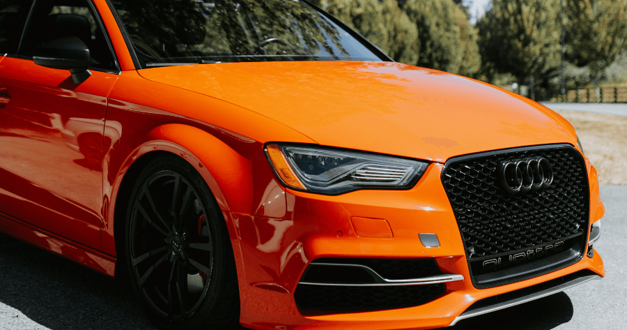 Close-up of an orange Audi A3's front grille and headlight